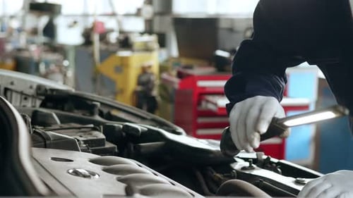 Man Working on Car in Auto Repair Garage