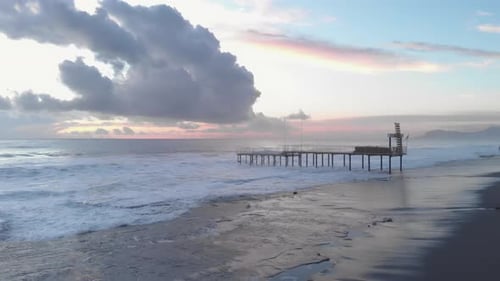 Powerful stormy sea. Sea waves splashing and creating white foam, crashing on rocky beach.