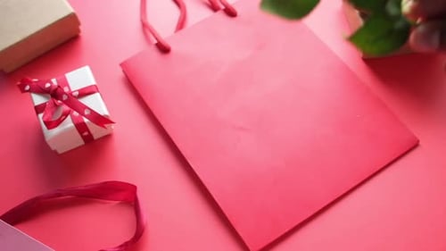 Top View of Gift Box and Rose Flower on Red Background