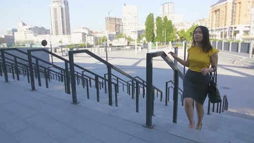Woman Walking Up Stairs in Urban City Setting