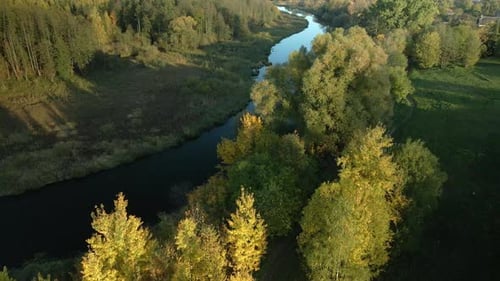 Park area. A winding river. Trees with yellow autumn leaves are visible. Aerial photography.
