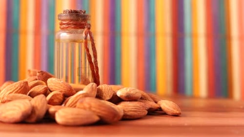 Almond Oil in Bottle on Wooden Background. Close Up