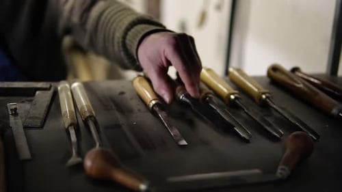 Hand selecting chisel from a collection of tools