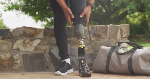 Front view man readjusting his prosthetic leg
