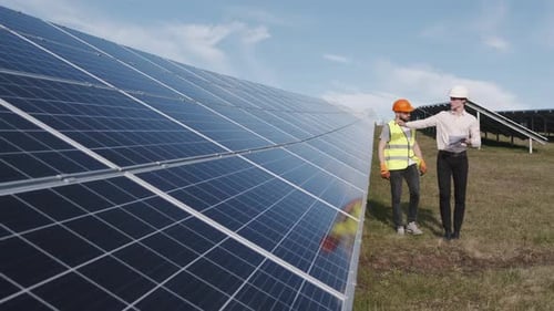 Un empresario y un trabajador caminan por la central solar