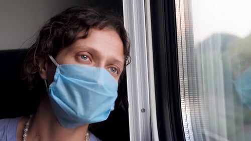 Une femme d'affaires aux yeux fatigués part en train en regardant par la fenêtre. Virus COVID-19