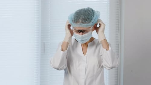 Young Adult Healthcare Worker Puts on Surgical Mask