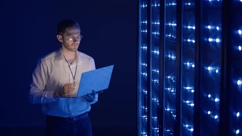 Young Adult Man Working in Dark Server Room