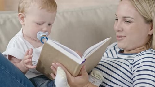 Fair-Haired Baby and Woman Reading on Couch