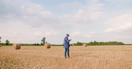 Farmer Using Digital Tablet While Examining Field