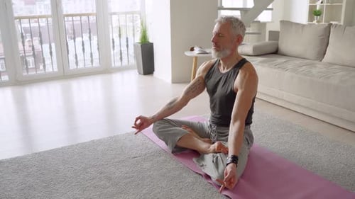Mature Man Practicing Yoga Headstand in Living Room