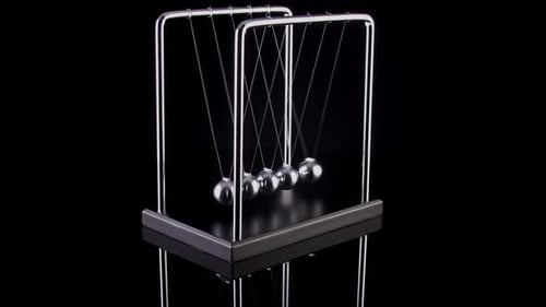 Newton's Cradle Demonstrating Momentum on Black Background