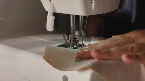 Hands Guide Fabric Through Sewing Machine Needle
