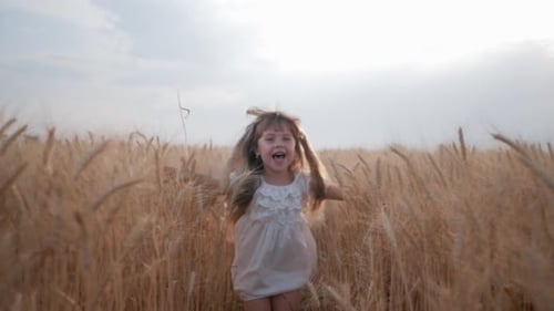 Girl Runs Laughing Through Golden Wheat Field