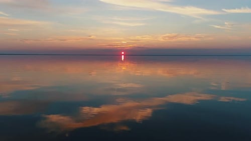 Aerial Drone Footage. Fly Over Calm Water To Sunset