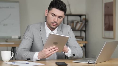 Businessman Using Tablet in Office