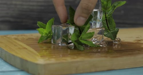 Ice Cubes and Mint Refreshment on a Wooden Board