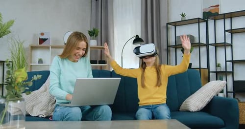 Child Using VR Headset with Adult on Laptop