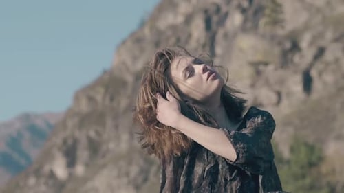 Woman With Flowing Hair Posing Near Mountains
