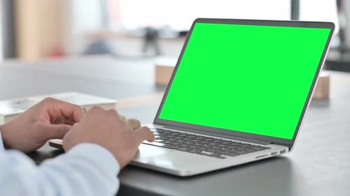 African Man Typing on Laptop with Green Chroma Key Screen