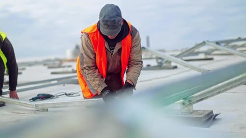 Technicians building metal base for solar panels