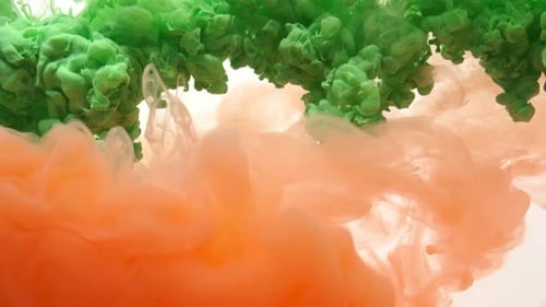 Grüne und orange Acryltinte in Wasser auf weißem Hintergrund. abstrakter Hintergrund.