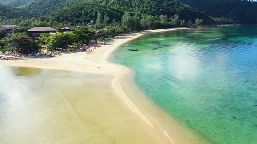 Farbenfrohe Küste einer tropischen Insel mit grüner Vegetation und weißem, von Türkis umspültem Sandstrand