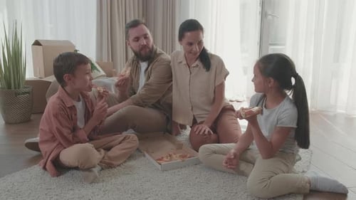 Happy Family Eating Pizza Together on the Floor