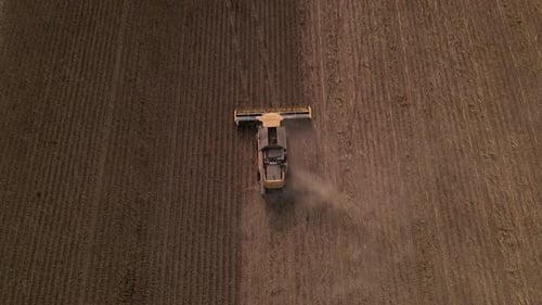 Top Down Slow Motion Aerial View of Combine Harvester Working on a Field