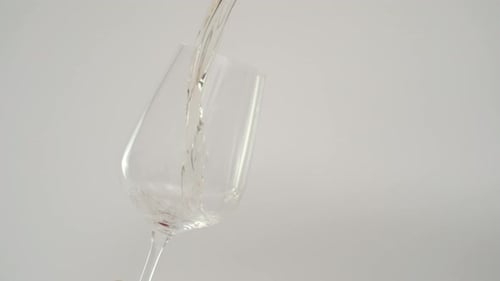 Clear Liquid Being Poured into an Empty Wine Glass