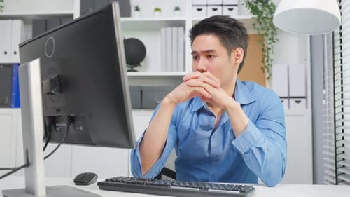 Young Man Working Attentively at Computer in Office