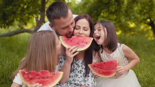 Happy Family Enjoys Watermelon Snack Outdoors