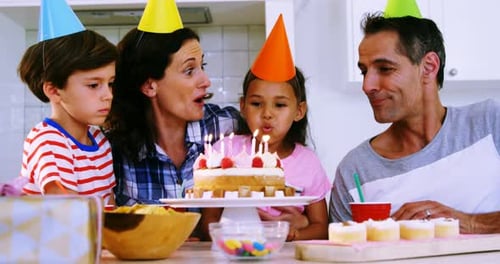Family Celebrates a Birthday with Cake and Fun