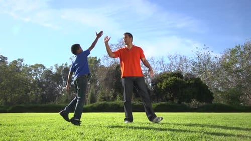 Father and Son Playing Football in the Park