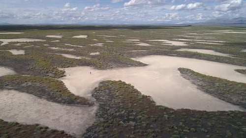 Flying over vast desert as person walks across sand