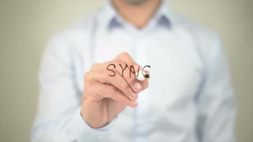 Hand Writes 'SYNC' on Transparent Surface Close Up
