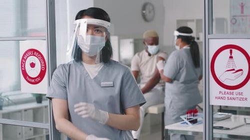 Medical Professional Standing in Front of Clinic Doorway