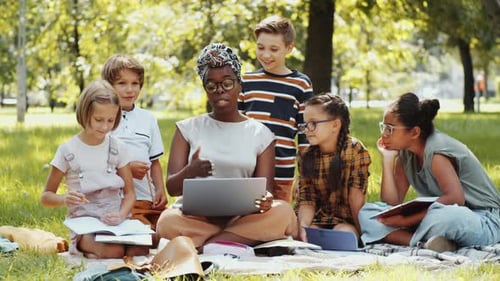 Multiethnic Kids and Afro-American Female Teacher Having Lesson in Park