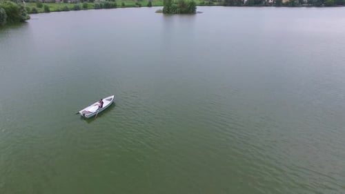 Elegant Couple Rowing on a Calm Lake