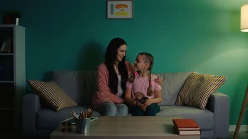 Happy Mother and Daughter Sitting on Couch Together