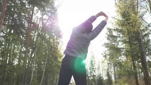 Back view of asian woman standing in the forest to see a beautiful nature in the morning