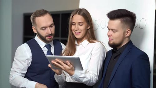 Colleagues Discussing Data on Tablet in Modern Office