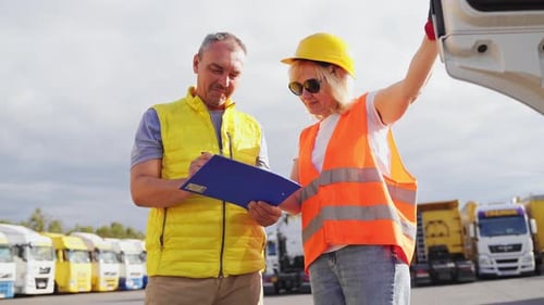Mature Woman and Man at Cargo Warehouse Truck Drivers Delivery Inspection