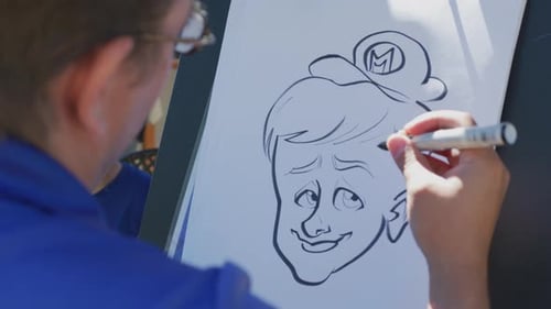 Artist Drawing Cartoon Caricature with Marker on Paper