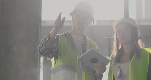 Engineers or Architects Have a Discussion at Construction Site Looking Through the Plan of