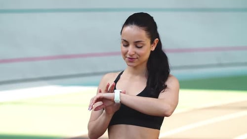 Portrait of Fitness Woman Checking Results at Smart Watch at Sport Stadium