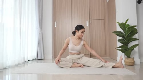 Woman Performing Yoga Stretches in Bright Home Interior
