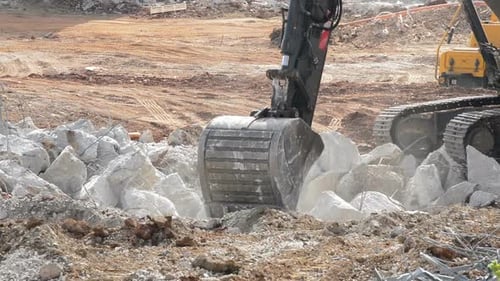 Excavator Shovel Working on the Demolition of a Building