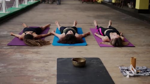Women Relaxing After Yoga on Wooden Terrace