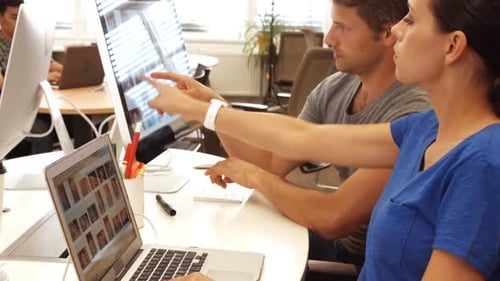 Executivos de negócios discutindo sobre laptop e computador